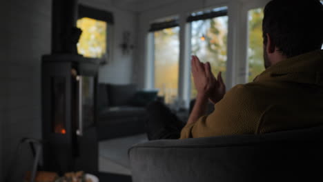 man-sitting-near-fireplace-trying-to-get-warm