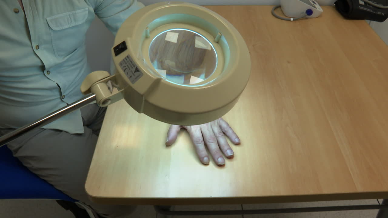 Medical Examination of a Hand with Magnifying Lamp