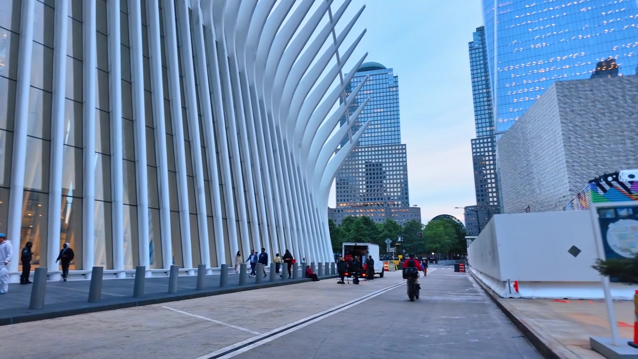 2026年6月5日，美国纽约：Oculus交通枢纽外部，伴有行人。宽阔的街景，白色弧形肋状立面沿路延伸，行人、办公大楼和背景中的树木