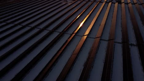una toma de drones de los rayos solares que se reflejan en los paneles solares durante la puesta de sol