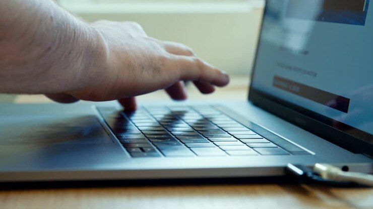Man hands typing on a laptop computer keyboard