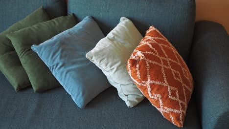 colorful pillows on a teal sofa