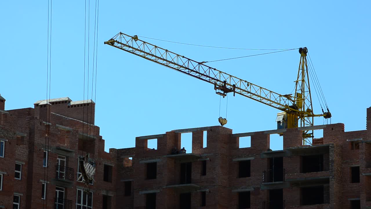 Construction cranes over houses. Construction of residential buildings