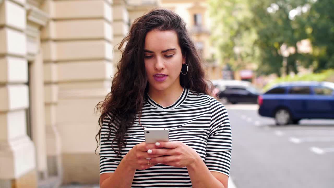 Ragazza che usa un telefono cellulare per strada
