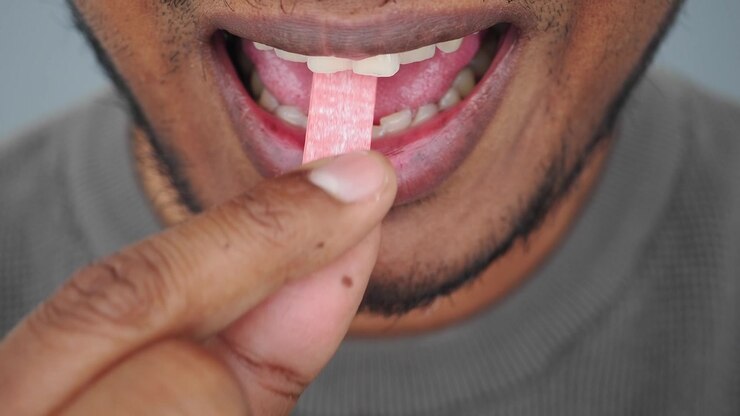 Man Placing a Piece of Chewing Gum into His Mouth