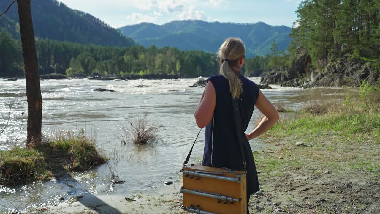 Woman Artist Painting by a River in the Mountains