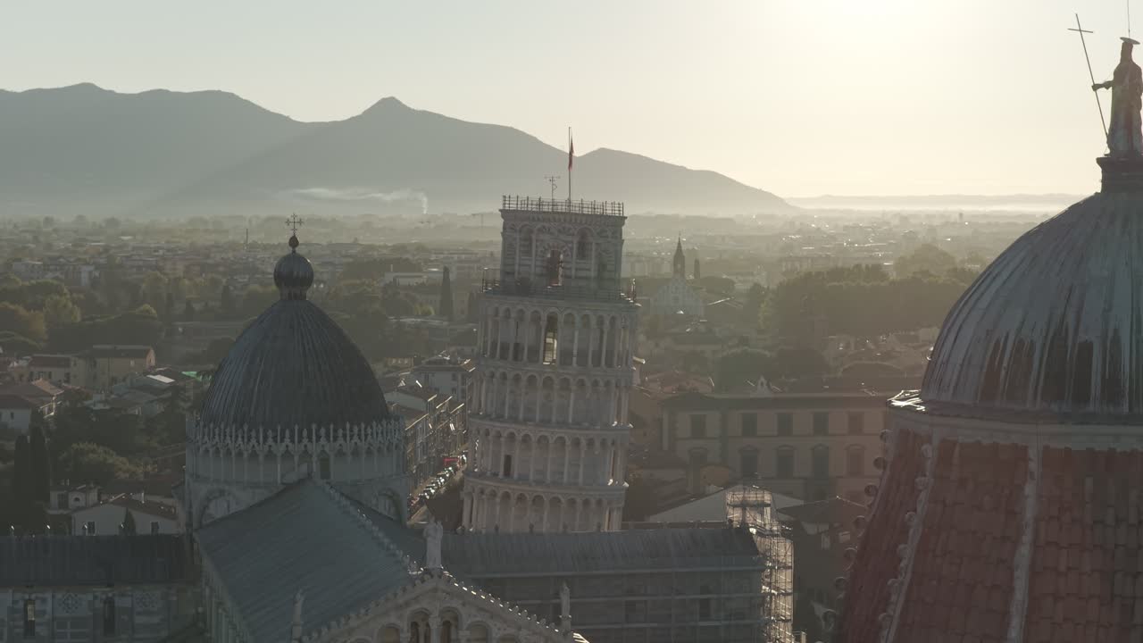Cinematic sunrise drone footage of the Leaning Tower of Pisa and the Piazza dei Miracoli, captured with smooth aerial movements and soft early morning light