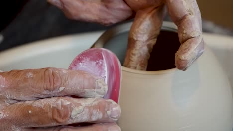 Close-up-of-the-potter's-hand-shaping-and-molding-clay-on-a-turning-wheel-