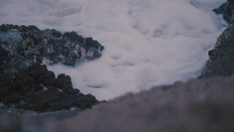 Pequeñas-Olas-De-Agua-Espumosa-Blanca-Se-Derraman-Entre-Las-Grietas-De-Varios-Barnicle,-Rocas-Cubiertas-De-Limpito-En-Un-Cálido-Día-De-Tarde