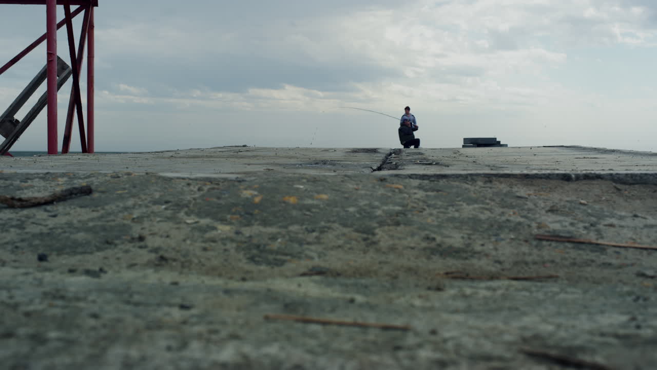 ⁇ 시 ⁇ 이 갈색 날씨에  ⁇ 을 사용하여 강 부두를  ⁇ 시합니다. 사람들은 물고기를 잡습니다.