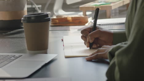 close up woman hands writing notes brainstorming working on creative project in office