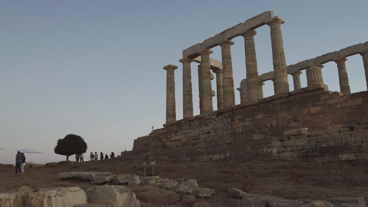 Slow motion pan across Temple of Athena Sounias at sunset