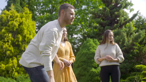 side view of caucasian young woman throwing a petanque ball in the park on a sunny day