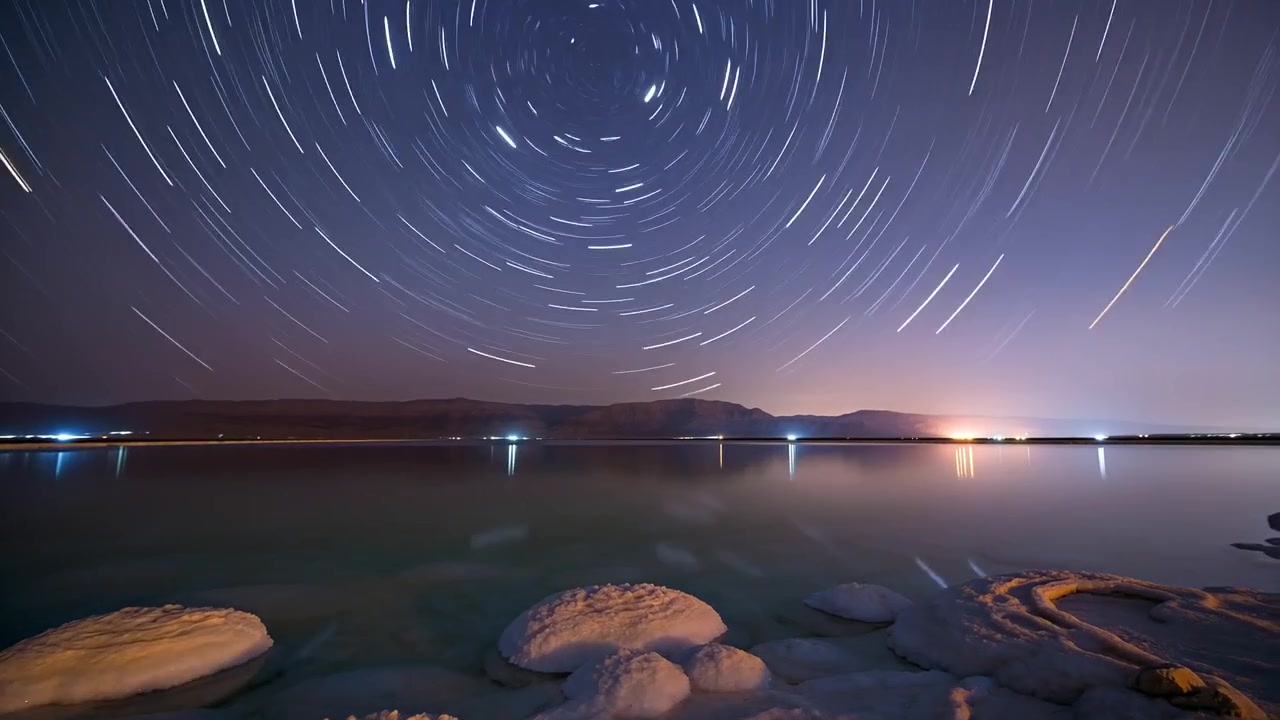 Starting timer, camera filming circular star trails above salt mounds at night to record sky motion