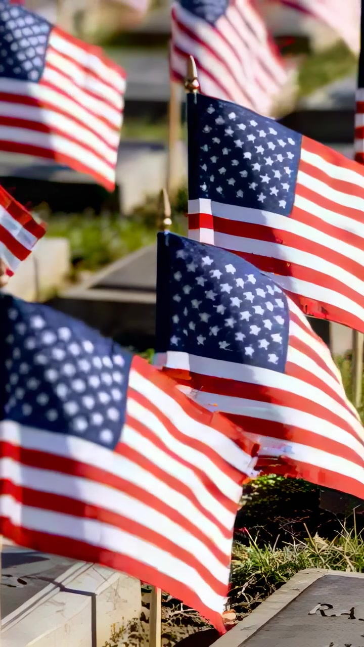 Vertical video: Rippling US flags swaying among grave markers in cemetery, breeze rotating flags