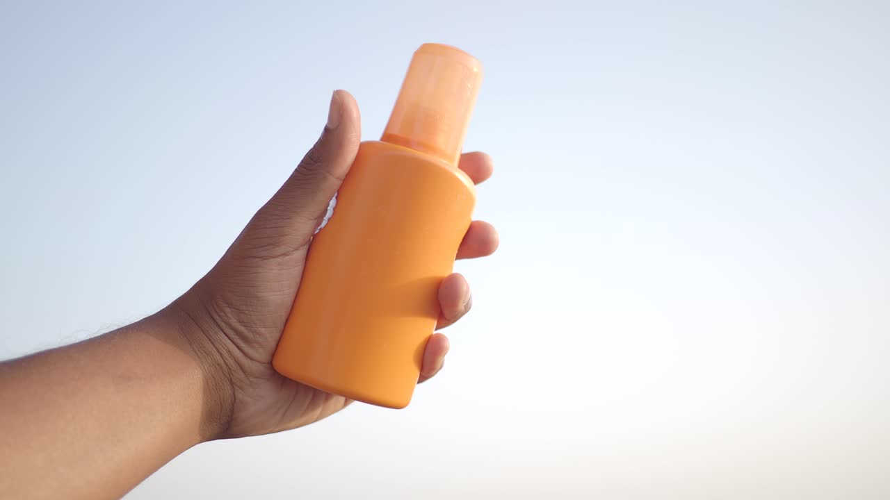 Person holding bottle of sun screen