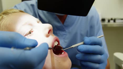 dentista examinando a un paciente joven con herramientas