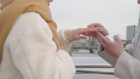 Young-Asian-Couple-With-Romantic-Man-Proposing-To-Woman-Against-City-Skyline-3