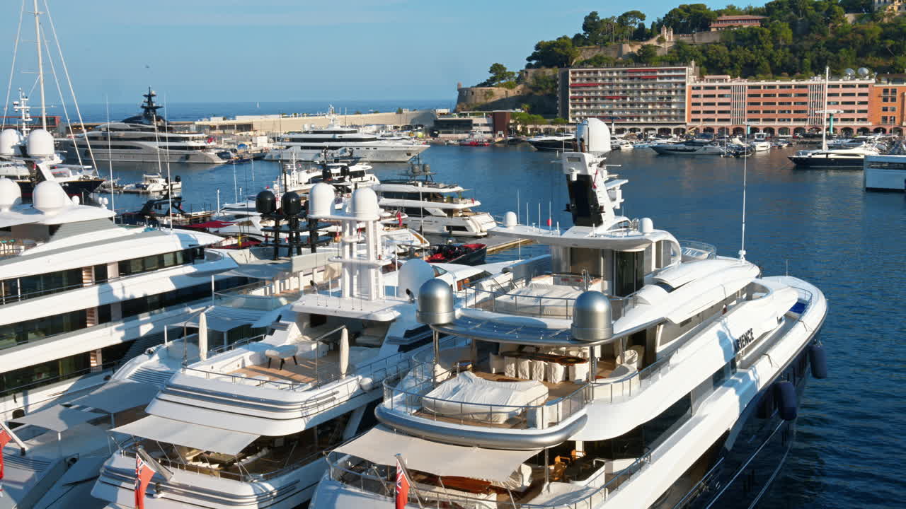 Vista di barche bianche ormeggiate nel porto turistico di Monaco con lo skyline della città sullo sfondo
