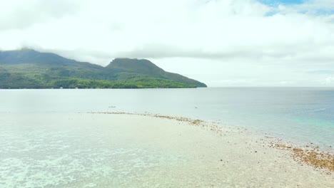 üppig-Grüne-Tropische-Insel-Im-Pazifischen-Ozean-Drohne-über-Seichtes-Wasser-Und-Korallen