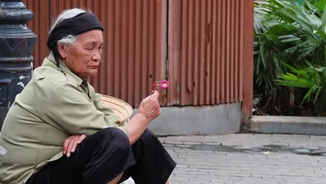 senior street vendor displaying small items for sale