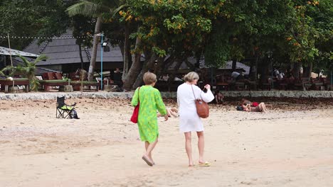 two people walking along a sandy beach