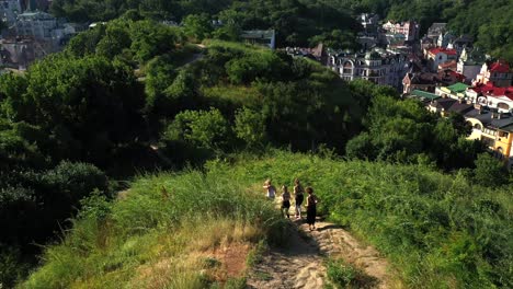 people hiking on a hill with city view