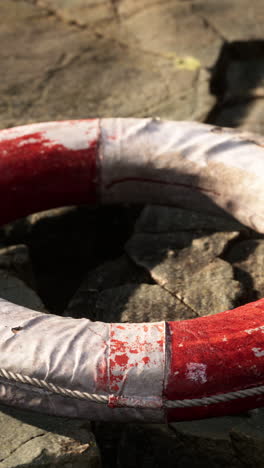 old life preserver on rocks