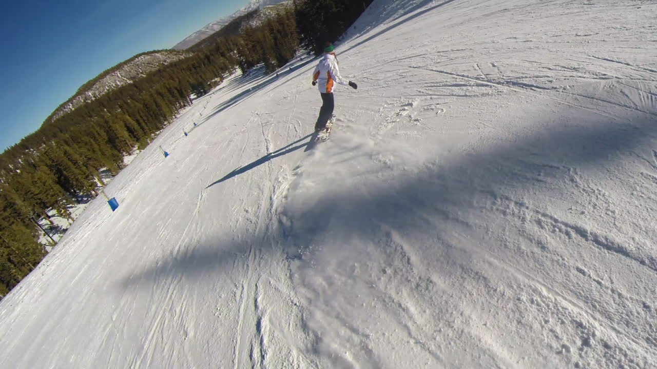 en busca de una chica practicando snowboard en el resort.