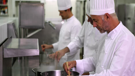 jefe de cocina agitando una olla grande en la estufa