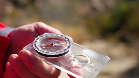 close up on an old scratched magnetic compass being used in an emergency survival situation to find the trail and not get lost