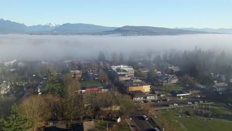 fog over the fort langley village in the early morning in langley, british columbia, canada. - aerial shot