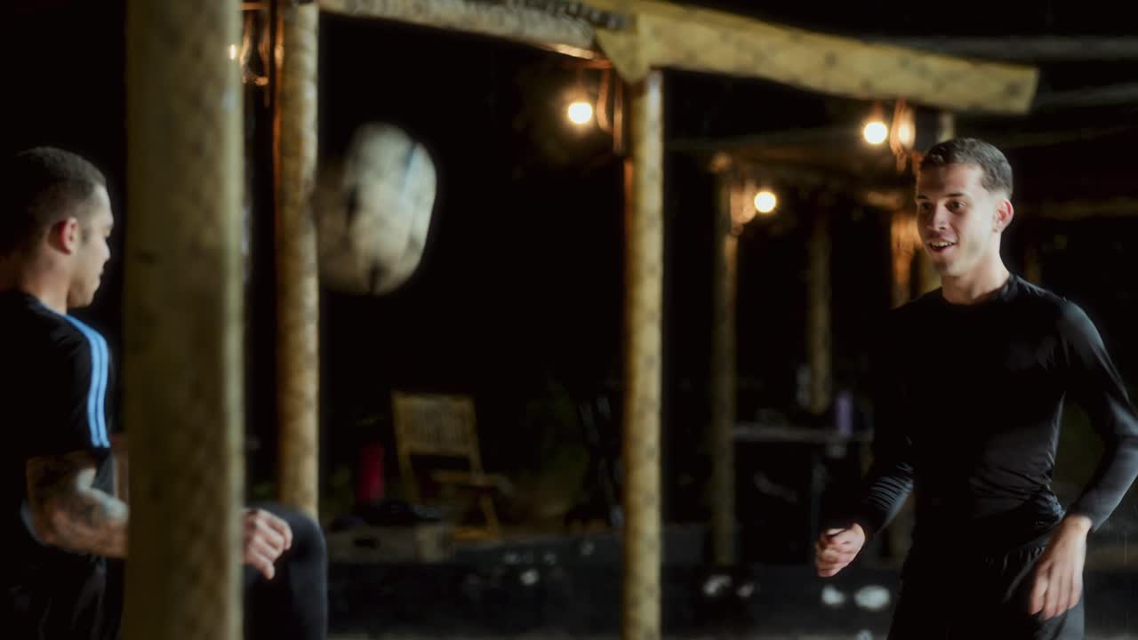 Men Playing Footbag Outdoors at Night