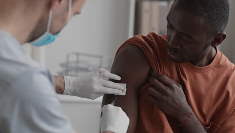 young man getting vaccine injection