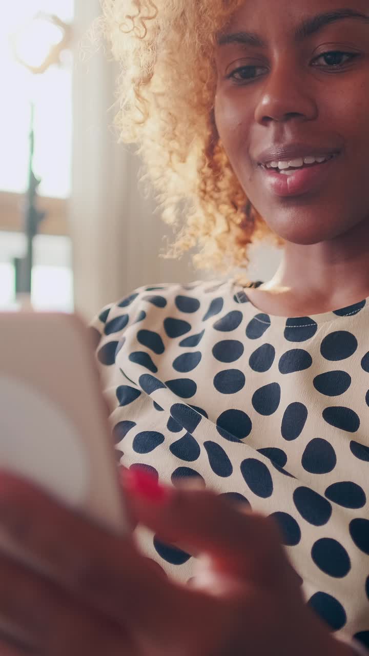 Young positive african american woman shows thumbs up making video call on phone