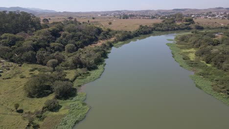 a rural house a river and the view of the inner city a small forest beside the river aerial view