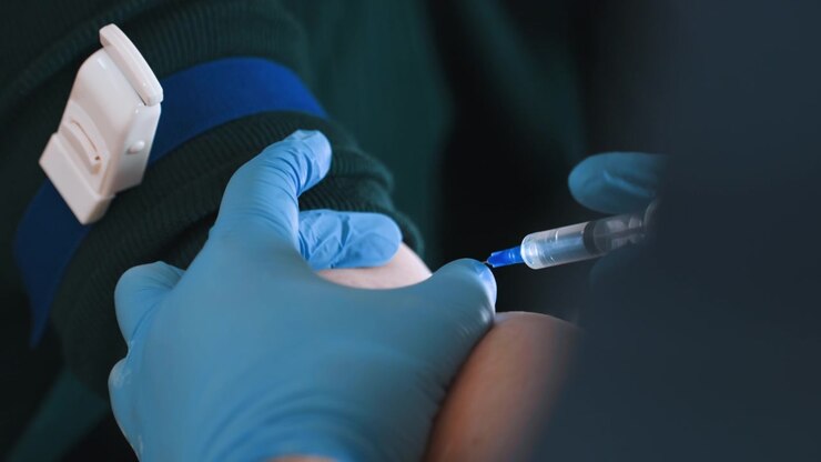 Closeup tourniquet tightened on arm before draw, gloved hands prepare syringe and vial, steady pressure on vein, clinical precision in residence, sample collection for lab, focused emergency care