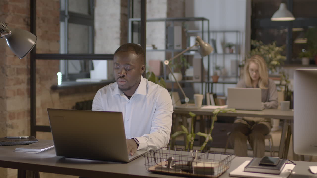 Serious American Man Working On Laptop Computer In The Office