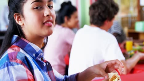 Portrait-of-happy-schoolgirl-having-sandwich-4k