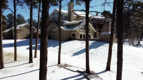 Slow-aerial-push-in-through-ponderosa-pine-trees-toward-a-mountain-mansion-in-the-Black-Forest-in-Colorado