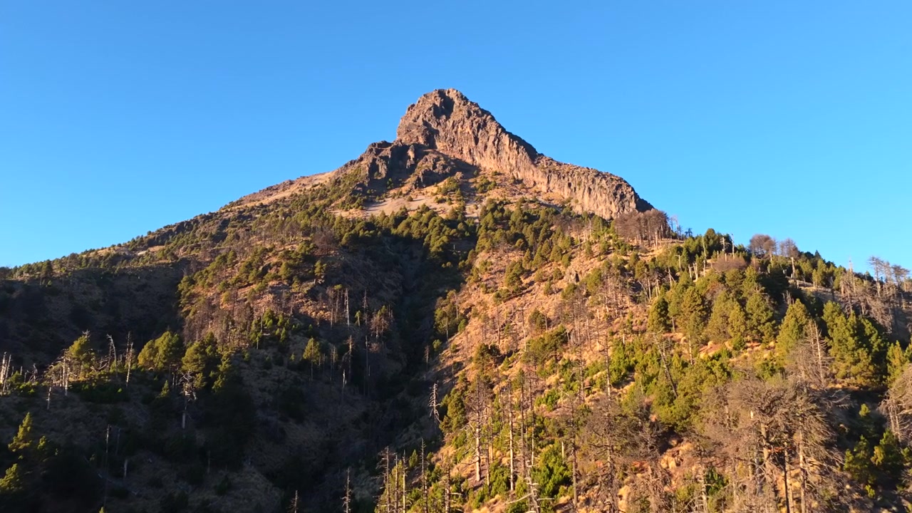 Cima del monte Nevado de Colima, Messico, che raggiunge un cielo azzurro limpido in una vista aerea in avvicinamento.