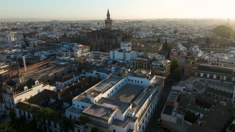 Volando-Sobre-El-Paisaje-Urbano-De-Sevilla-Con-La-Catedral-De-Sevilla-Al-Fondo-En-Andalucía,-España