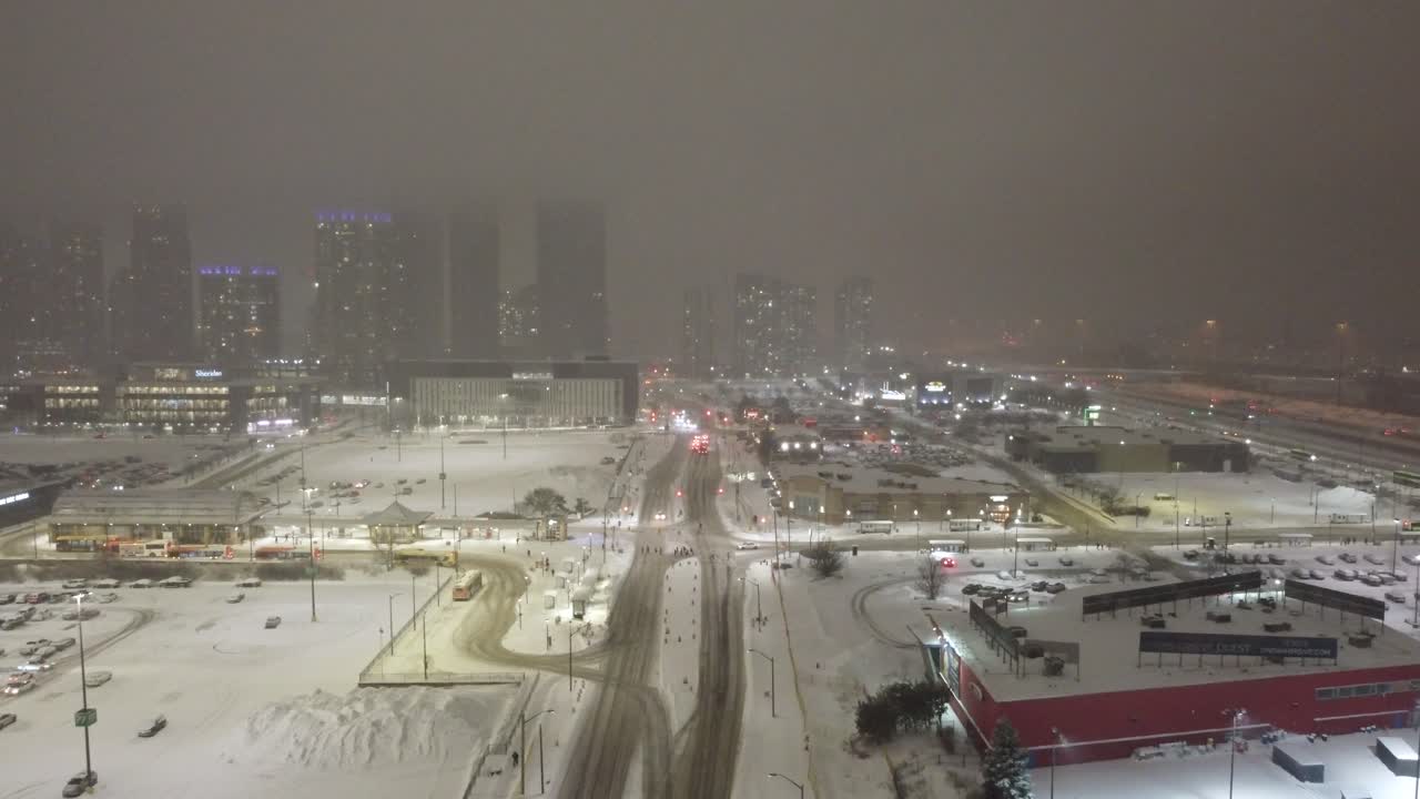 Snowy cityscape of Mississauga, Ontario, with illuminated skyscrapers in winter storm