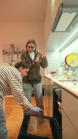 dos mujeres jóvenes cocinando juntas en la cocina