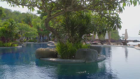 piscina junto a la playa con árboles en el hotel bintang flores, labuan bajo, indonesia