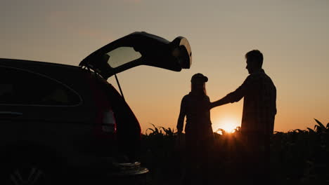 Una-Pareja-Joven-Discute-Frente-A-Un-Coche-Averiado.-El-Auto-Está-Estacionado-Al-Costado-Del-Campo-De-Maíz