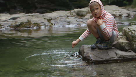 boy playing by a stream