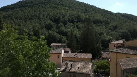 Aerial-Flying-Back-Past-Rooftop-Tiles-Of-Buildings-In-Rasiglia,-A-Small-Village-Located-In-The-Province-Of-Perugia