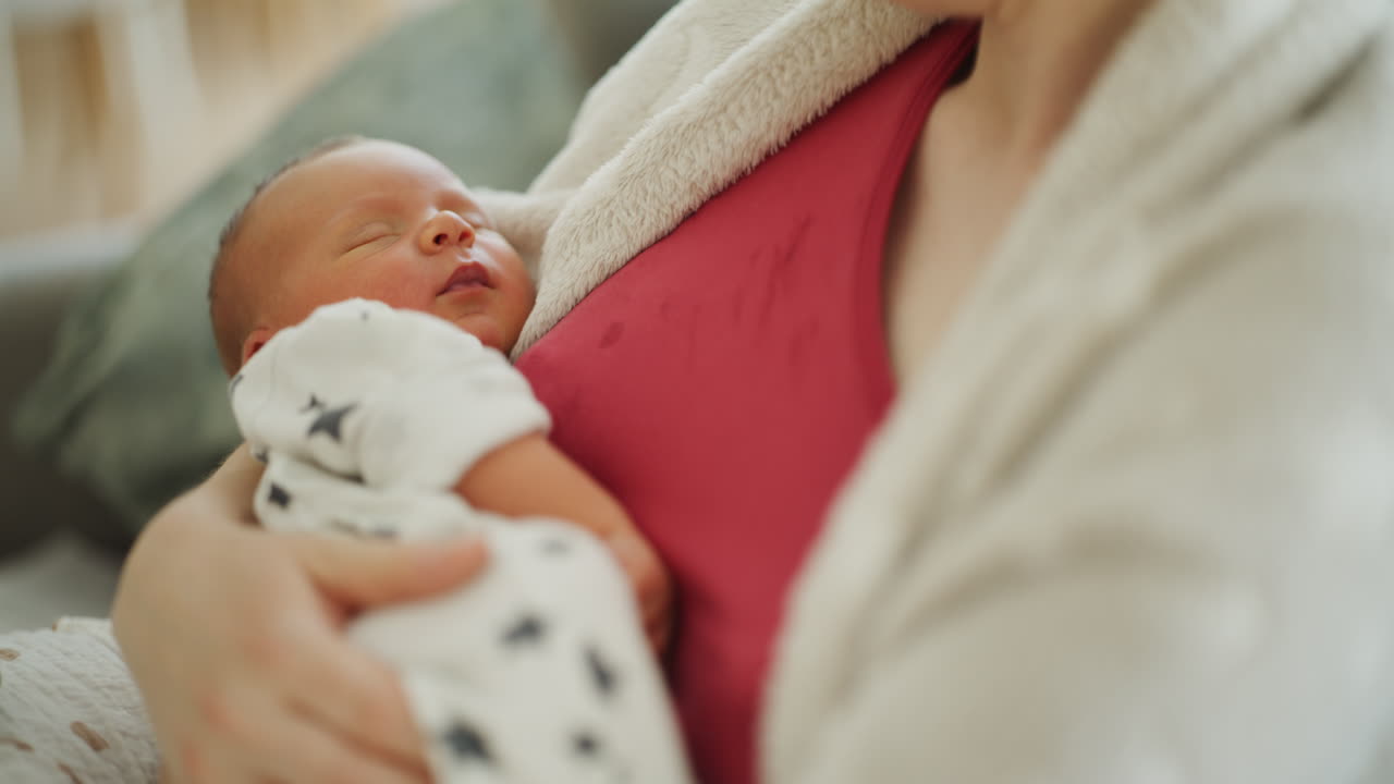Young Mother Cuddling Newborn Baby