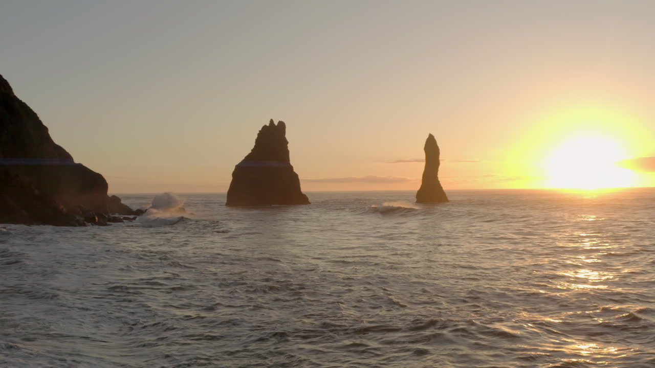 toma aérea de inversión de reynisdrangar pilas de mar más allá de columnas de basalto reynisfjara islandia